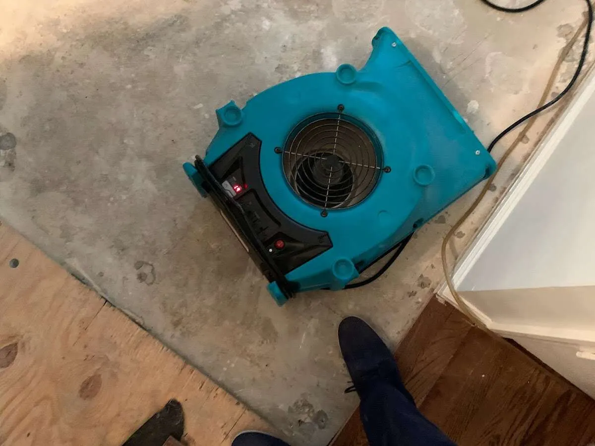 Air mover drying subfloor during Commercial Water Damage Restoration in Gardere